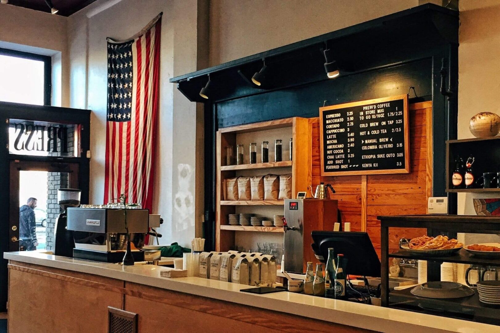 A coffee shop with an american flag hanging in the background.